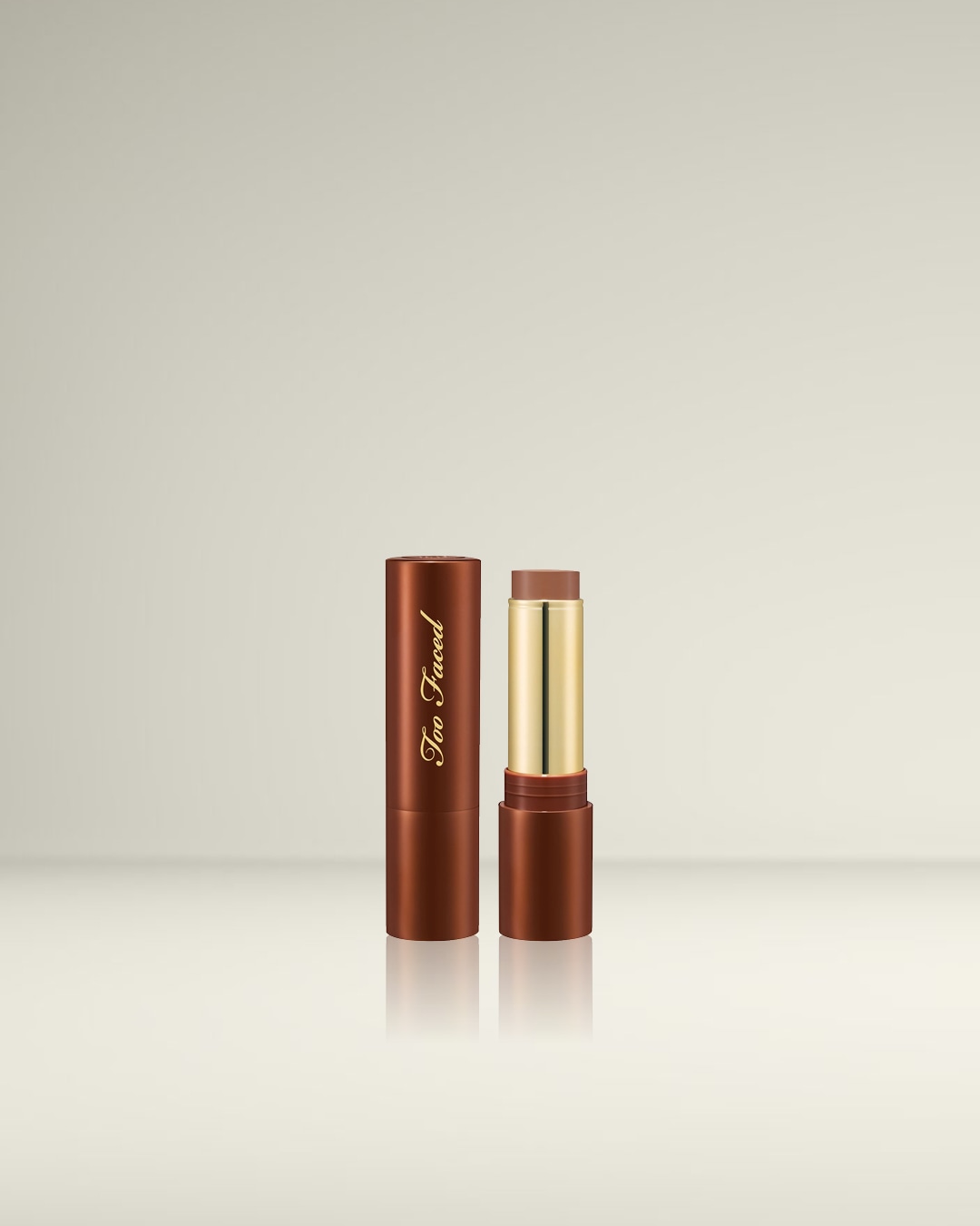 De Too Faced contourstick in een bruine verpakking met gouden letters, de dop is eraf en de stick is zichtbaar.