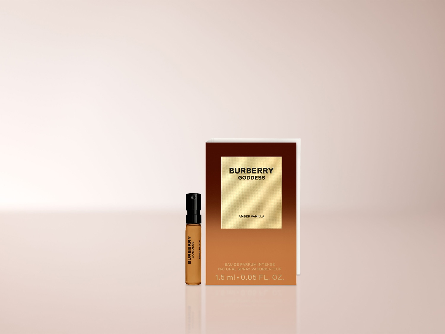 Das Bild zeigt eine kleine, durchsichtige Glasprobe des Burberry Goddess Amber Vanilla Eau de Parfum Intense mit schwarzem Sprühkopf, daneben eine braun-goldene Verpackung mit dem Schriftzug „Burberry Goddess Amber Vanilla“ und der Füllmenge 1,5 ml.