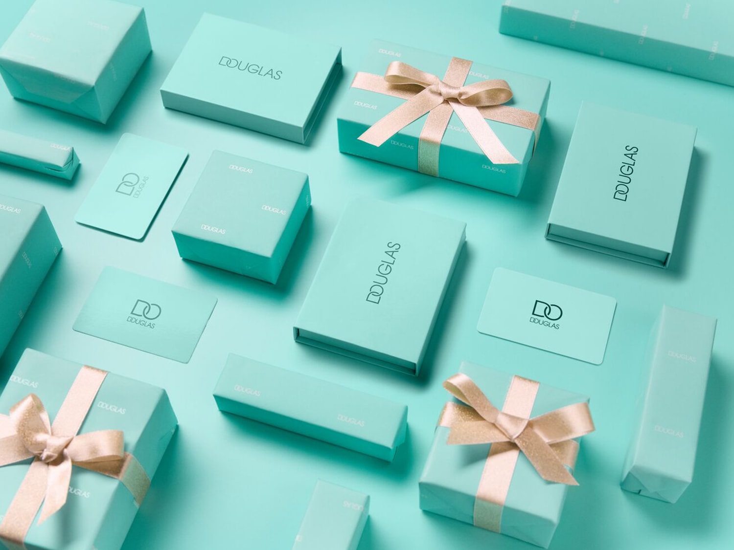 Découvrez une variété de coffrets cadeaux et de cartes cadeaux Douglas, présentés dans des tons turquoise apaisants, certains ornés de rubans dorés élégants, parfaits pour toutes les occasions.