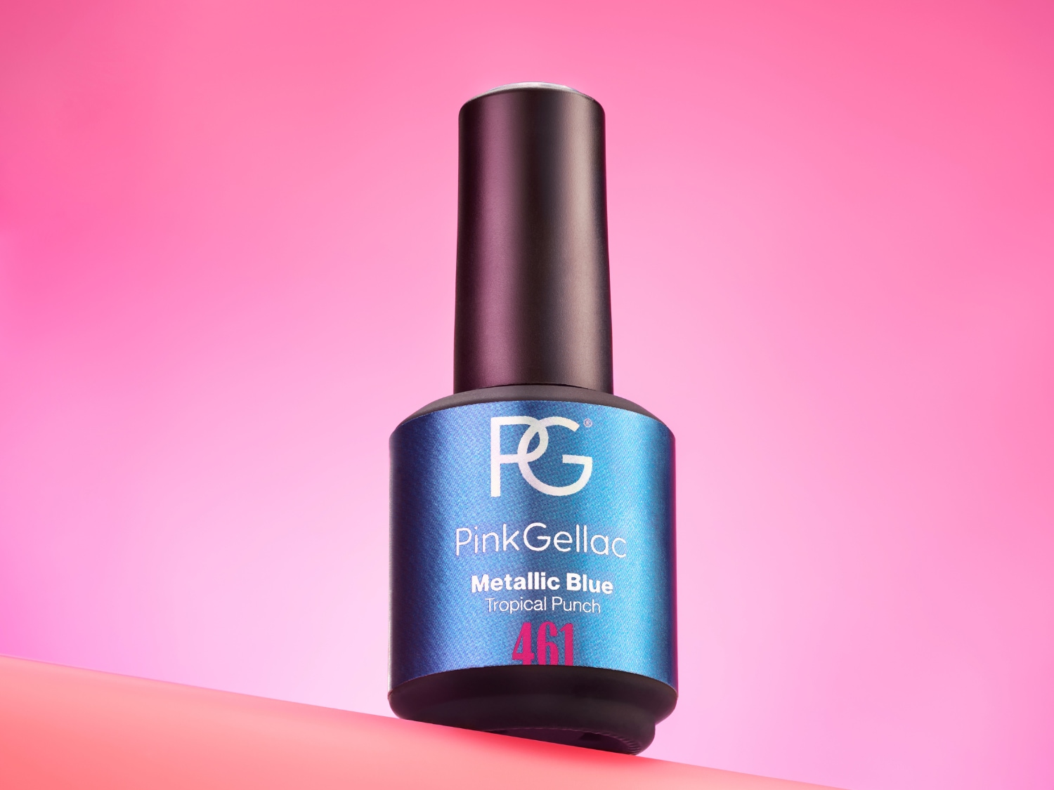 De Pink Gellac Metallic Blue Tropical Punch nagellak in een glanzend blauw flesje met zwarte dop, staat op een roze ondergrond.