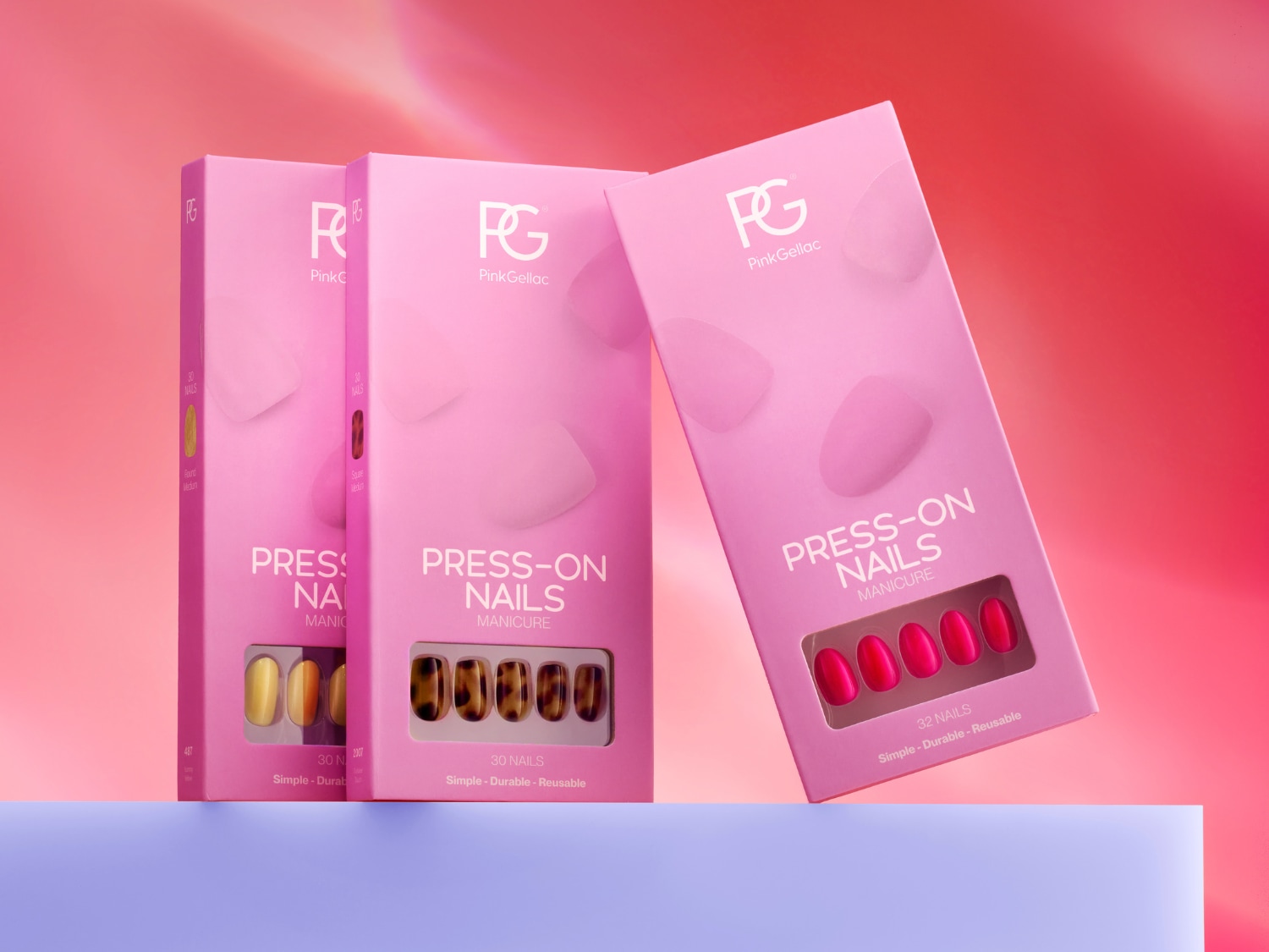 Trois boîtes de manucure Pink Gellac Press-On Nails sont présentées, avec des ongles de couleurs jaune, marron et rouge vif, offrant une solution simple, durable et réutilisable pour une manucure parfaite.