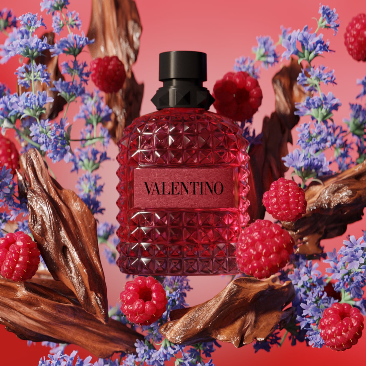 Ein roter, genieteter Valentino-Parfümflakon mit schwarzem Verschluss, umgeben von frischen Himbeeren, lila Lavendelblüten und dunklen Holzstücken vor einem leuchtend roten Hintergrund.
