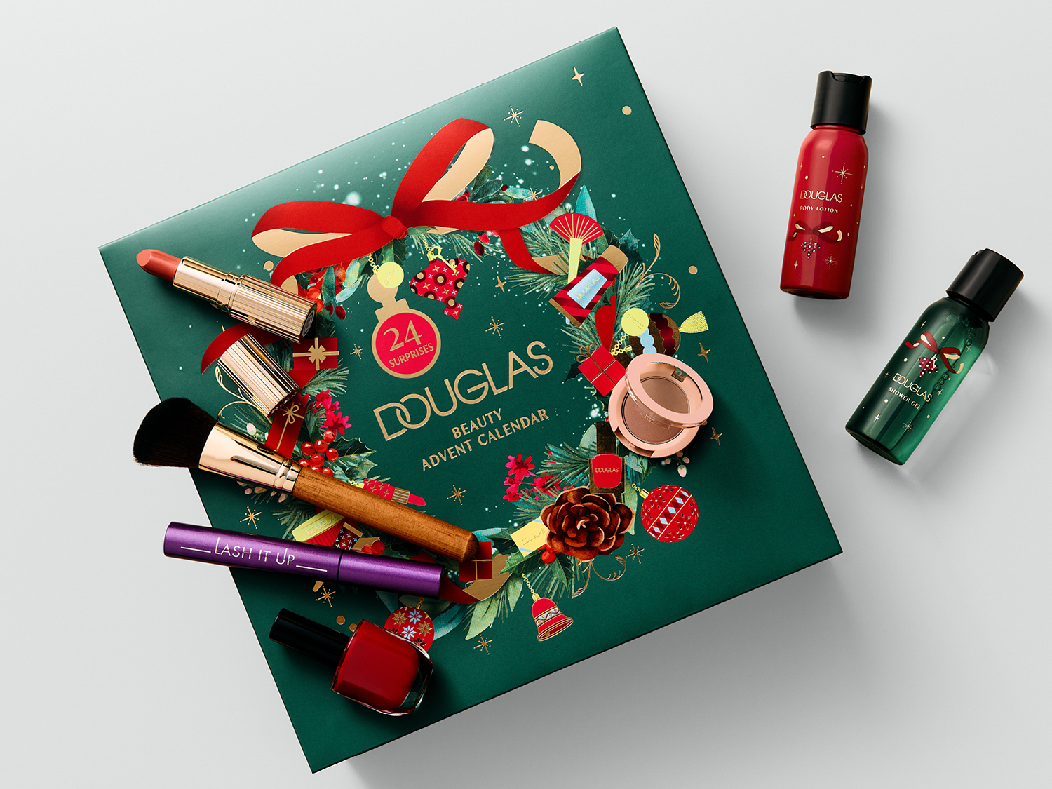 Le calendrier de l'Avent beauté Douglas, de couleur vert foncé, est orné d'un ruban rouge et de motifs de Noël, avec 24 surprises de maquillage et de soins, dont un rouge à lèvres corail, un pinceau de maquillage, un mascara violet "LASH IT UP", un vernis à ongles rouge, une poudre compacte, une lotion pour le corps rouge et un gel douche vert.