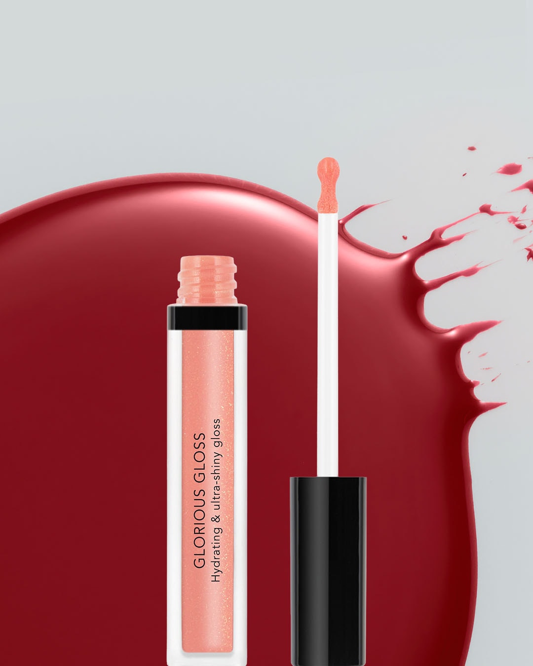 Błyszczyk do ust Glorious Gloss w odcieniu brzoskwiniowym, z aplikatorem, na tle rozlanej czerwonej farby, zapewnia nawilżenie i ultra-połysk.