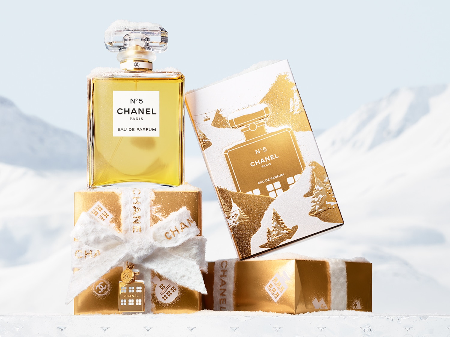 Ontdek de iconische Chanel N°5 Eau de Parfum in een feestelijke kerstverpakking met gouden accenten en besneeuwde cadeaus. Bestel nu en ervaar de magie!