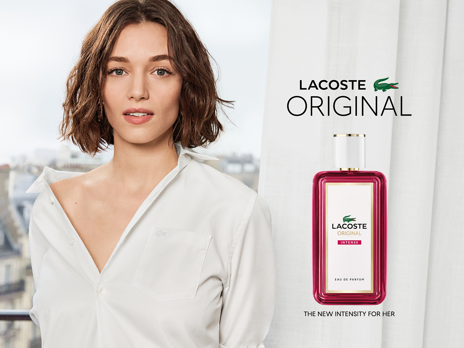 Młoda kobieta w białej koszuli prezentuje perfumy Lacoste Original Intense, nową intensywność dla kobiet. Odkryj wyjątkowy zapach i kup teraz w Douglas!